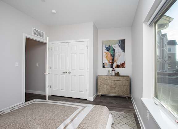 A room with a large painting on the wall and a cabinet.