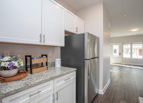A kitchen with white cabinets and a black refrigerator at MLK Apartments, Hartford, 06106
