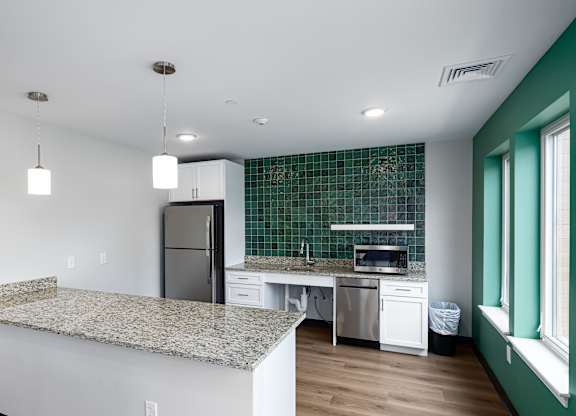 A kitchen with granite countertops and stainless steel appliances.