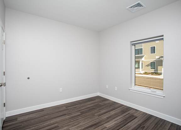 Empty room with a window and wooden flooring at MLK Apartments, Hartford, 06106