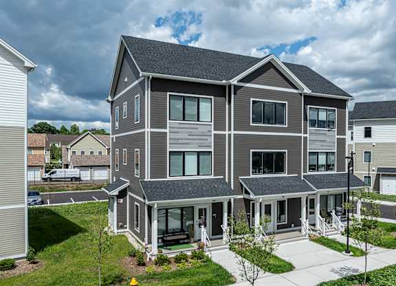 A modern two-story house with a front porch and a driveway.