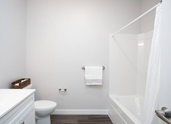 A white bathroom with a toilet, sink, and bathtub at MLK Apartments, Hartford, 06106