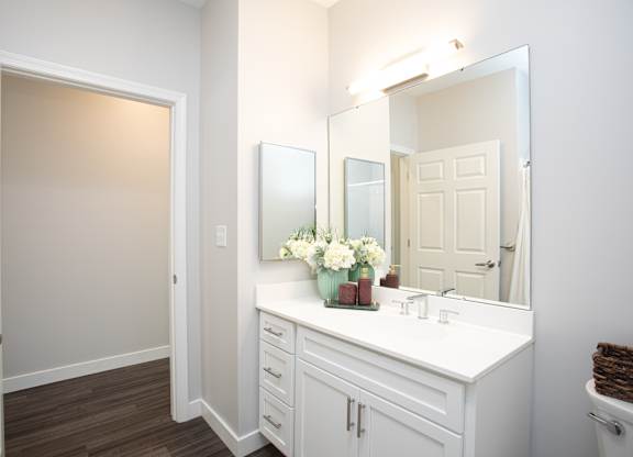 A white bathroom with a vanity and a mirror at MLK Apartments, Hartford, 06106