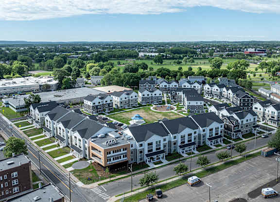 A large apartment complex with a parking lot in front.