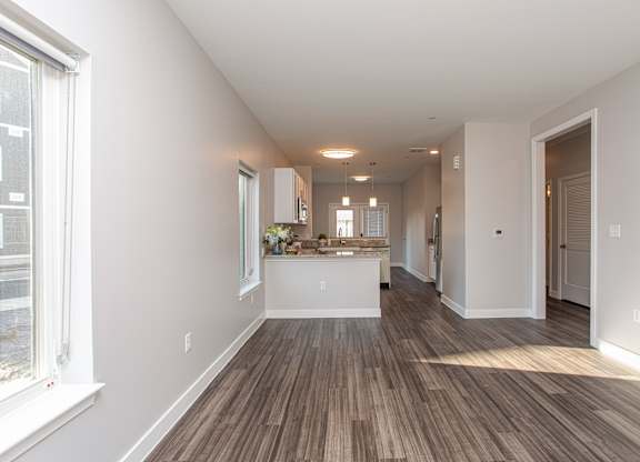 A long, empty hallway with a kitchen area at the end at MLK Apartments, Hartford, 06106