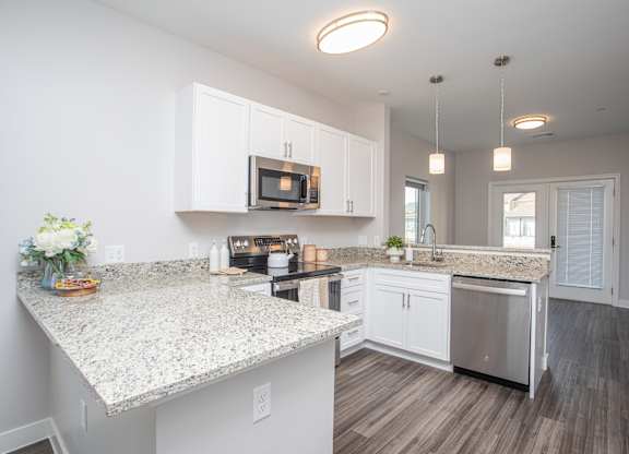 A kitchen with granite countertops and white cabinets at MLK Apartments, Hartford, 06106