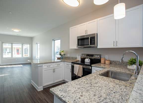 A kitchen with granite countertops and white cabinets at MLK Apartments, Hartford, 06106