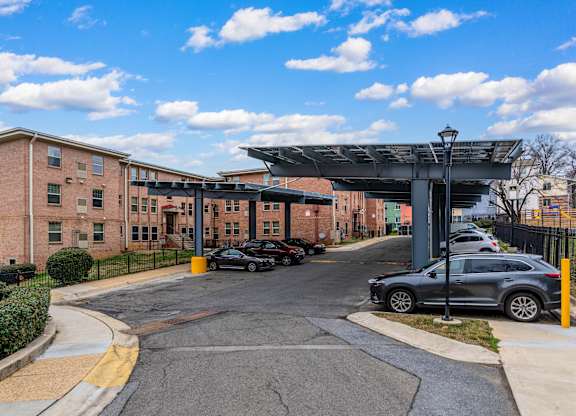 A parking lot with cars and a building in the background.