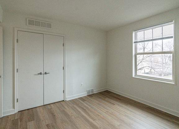 A room with a window and a wood floor.