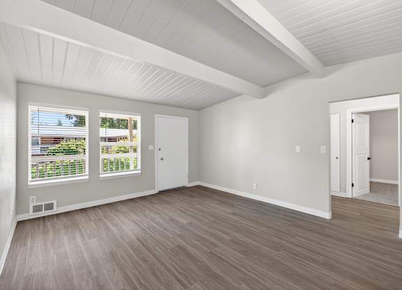 A living room room with a white ceiling and wooden flooring at Horizon Park Apartments