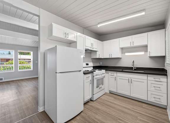1 Bedroom Apartment Kitchen at Horizon Park with white cabinets, dark countertops, and wood plank flooring