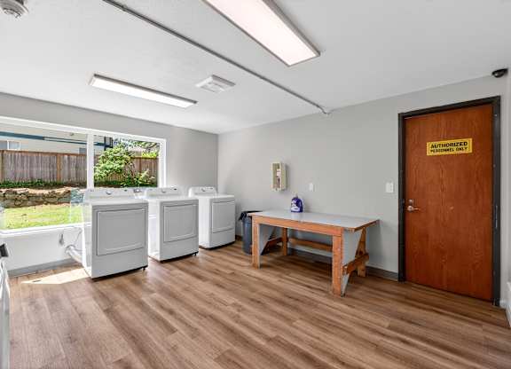 Horizon Park Shared Laundry with white washer and dryers and wooden floors
