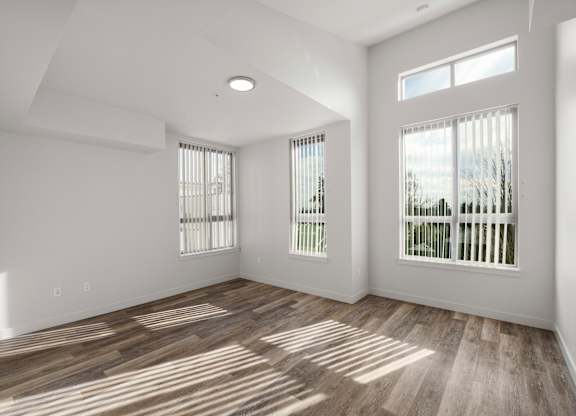 Modern 1-bedroom apartment in Seattle at Bode-88 featuring oversized windows, luxury vinyl plank flooring, and high ceilings