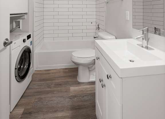 1-bedroom apartment at Bodde-88 with modern finished bathroom with white vanity and quartz counter top, includes a washer and dryer and shower and tub combination