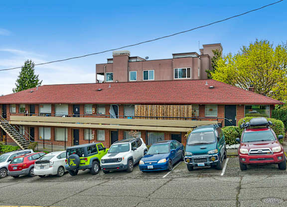 a building with a parking lot full of cars in front of it