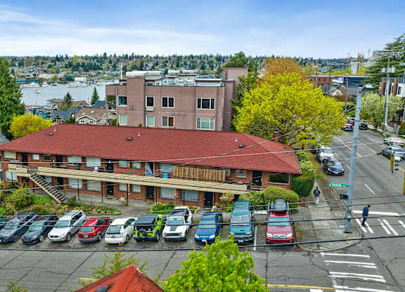 an aerial view of a building with a parking lot with cars