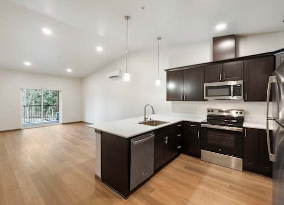 A modern kitchen with black cabinets and stainless steel appliances.