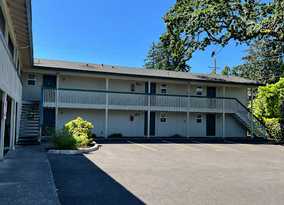 A parking lot in front of a two-story building.