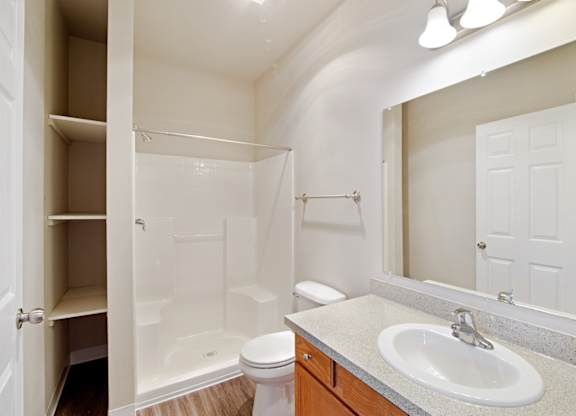 Bathroom with storage, single vanity, and shower tub combo at Hearthstone Apartments