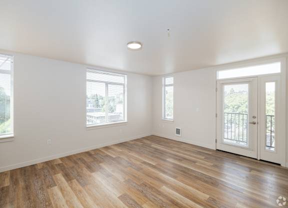 Living Room in Bode125's 1-bedroom apartment with several windows, luxury vinyl plank floors, and white walls