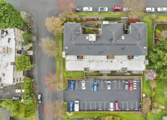 a birdseye view of a house and parking lot from above