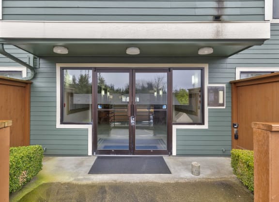 the front entrance of a house with glass doors and a patio