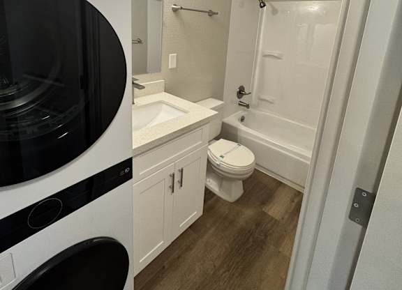 2-bedroom bathroom with a white & black washing machine and dryer and a shower & tub combination at Bridgeport Terrace Apartments