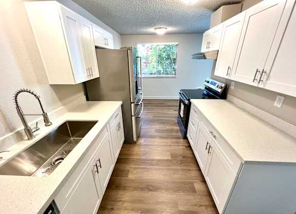 2-bedroom kitchen at Bridgeport Terrace Apartments with white cabinets, white quartz countertops, and stainless steel appliances