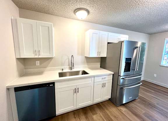 2-bedroom kitchen at Bridgeport Terrace Apartments with white cabinets, white quartz countertops, and stainless steel appliances