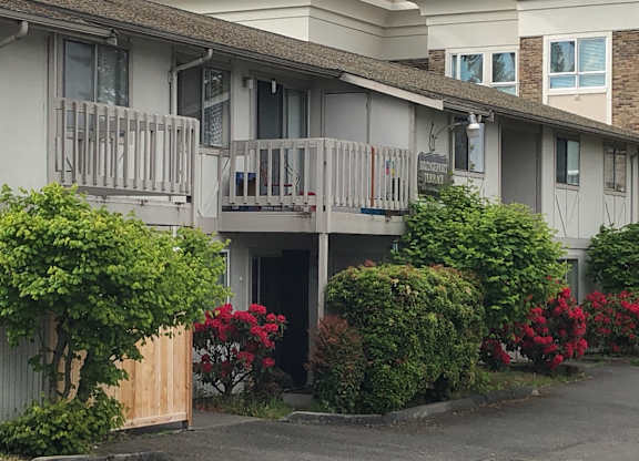 A balcony with shrubs beneath for Bridgeport Apartments