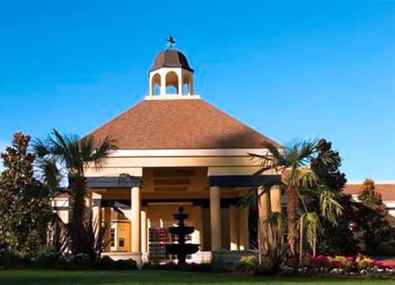 a building with a bell tower and palm trees