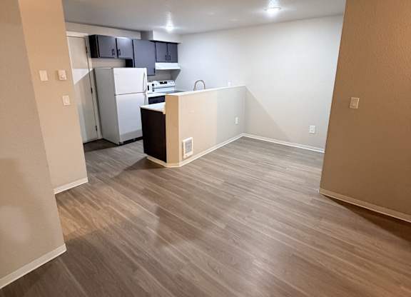A kitchen area with a refrigerator, microwave, and oven.