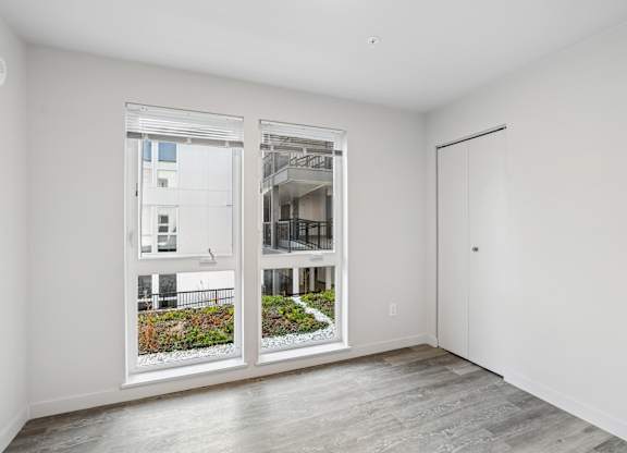 A room with a view of a building through the window.