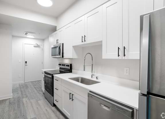A kitchen with white cabinets and stainless steel appliances.