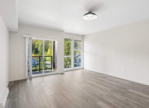 A spacious room with a sliding glass door leading to a backyard.