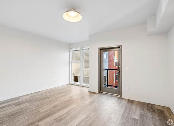 A room with a sliding glass door and a wooden floor.