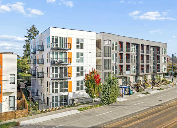 A modern apartment building with orange and grey accents.