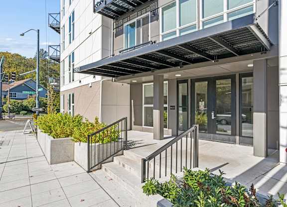 A modern building with a glass entrance and a metal railing.