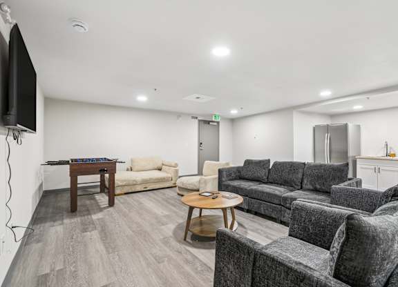 A living room with grey couches and a wooden coffee table.