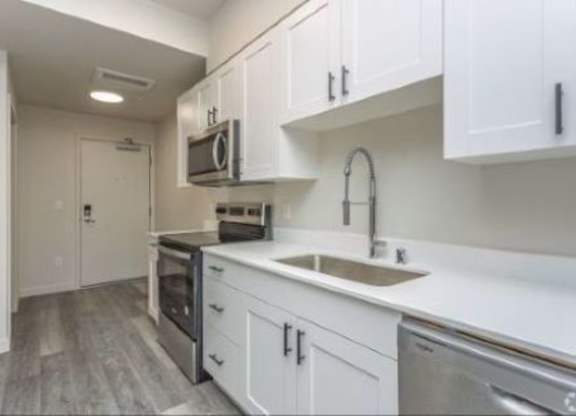 A kitchen with white cabinets and stainless steel appliances.