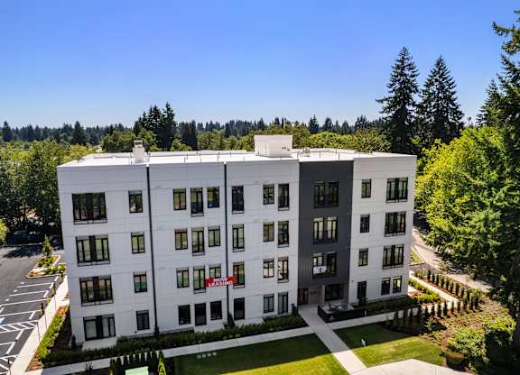 A large white building with a red sign on the front at The Hub Apartments, Lacey
