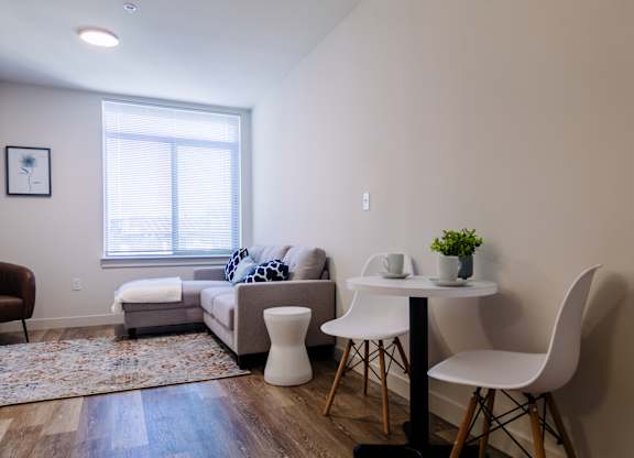 ADA accessible studio apartment at Bode125 with living room staged with small table and chair set, a sofa, and a rug