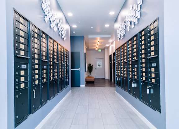 Hallway with a series of mailboes on both sides and a bench in the middle at Bode125 apartments