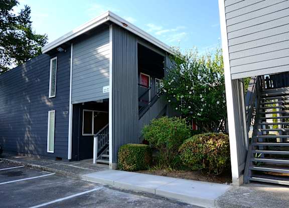 A grey building with a white door and windows.