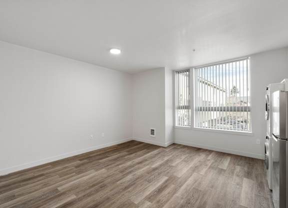 A room with wooden flooring and white walls.