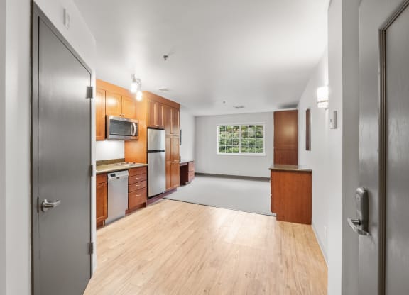 an empty kitchen with wood floors and stainless steel appliances