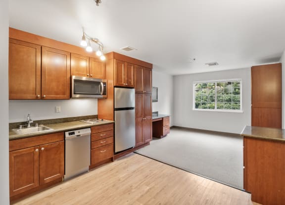 an empty kitchen with wooden cabinets and stainless steel appliances