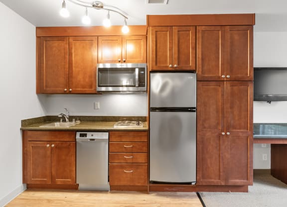 an empty kitchen with wooden cabinets and stainless steel appliances