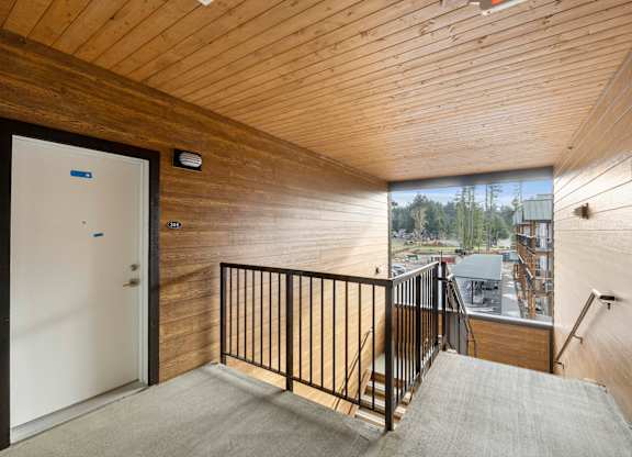 A room with a wooden ceiling and a white door.