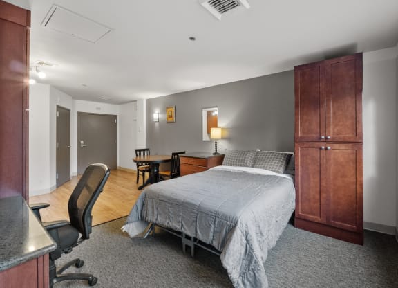 a bedroom with a bed and a desk and a chair